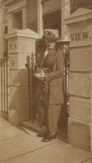 Minnie Taylor dressed in early 20th century style outside her home/boarding house | Jean Calder