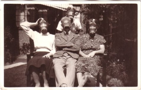Photo of Gordon Harris (at the rear of the group) and family wearing gas-masks