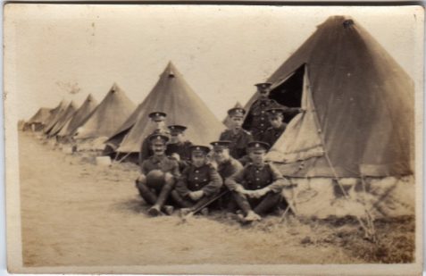 Photograph of a group of soldiers outside a line of tents