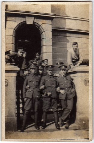 Photograph of a group of soldiers standing on steps of a building