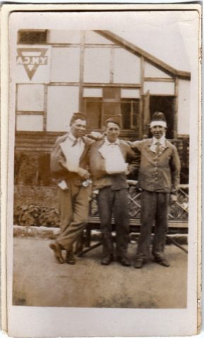 Photograph of three injured men standing outside the YMCA
