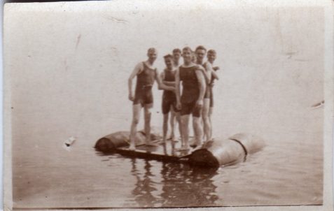 Photograph of a group of men [possibly off-duty servicemen] in bathing suits on a raft