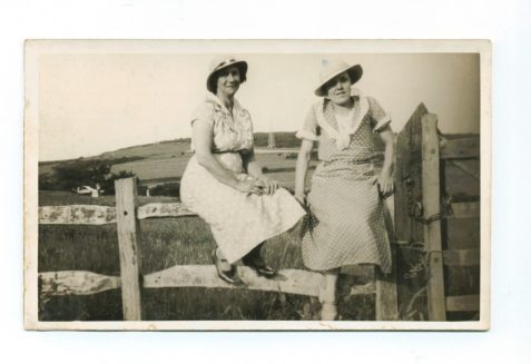 Photograph of Florence Langrish (seated on fence on left) with her neighbour Mrs Harrison