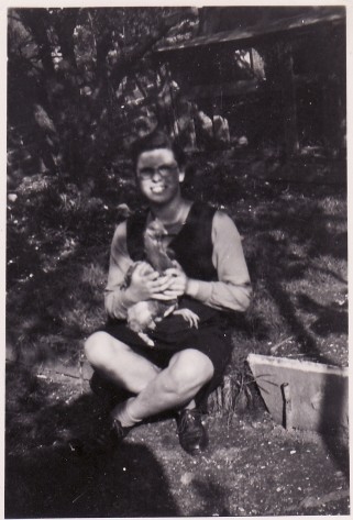 Photo of Margaret Rich holding chicken in back garden, 1945