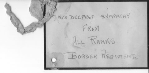Handwritten message of sympathy on a black-bordered florist's tag from the Border Regiment.