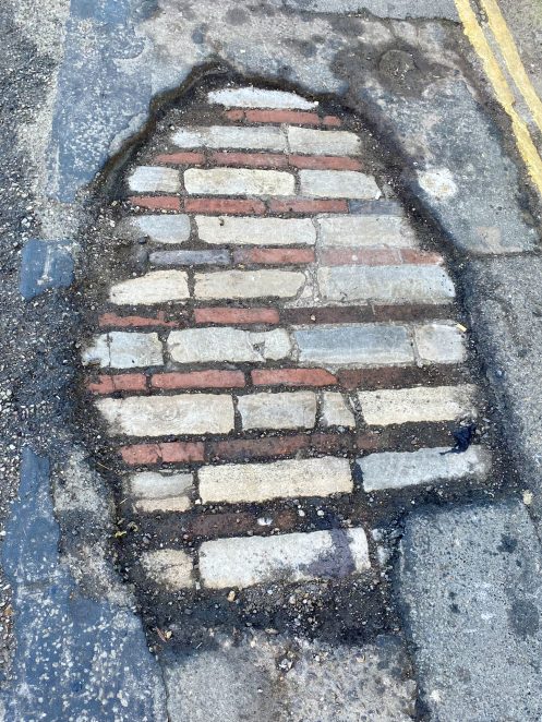 A pothole reveals a lost road surface.