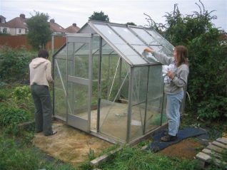 Up goes the donated greenhouse | Photo by Mike Bliss