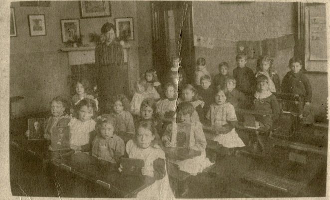 Children at St. Andrew's taken approx 1916. Some of the children are holding photos of military. Back row on the right is Basil Heryet age 7. | From the private collection of Eileen Heryet