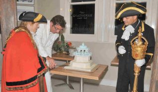 The Mayor of Brighton and Hove, Councillor Ann Norman, watched by the City Macebearer, Robert Robertson, cuts the celebration cake | Photo by Tony Mould