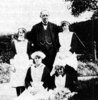 Daisy 'in service' at Ovingdean Hall. Pictured here (back left) with the Butler and some of the other girls on the staff. | Donated by Daisy Noakes