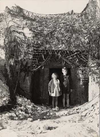 Photograph of Margaret Sinden's children, Caryn, aged 5 or 6 and Neil, aged 8 or thereabouts. They are playing in the bunker that was used for the filming of 'Oh! What a Lovely War'. | Image reproduced with permission from Brighton History Centre, initially donated by Margaret Sinden.