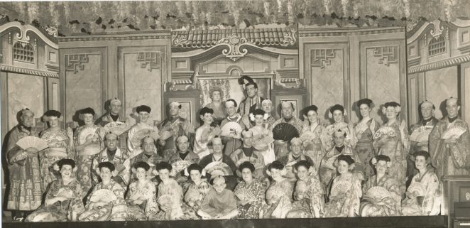 Full company for the Mikado:The names I can recall are all left to right starting at the back working forwards. Top = Lily Elmer as Katisha, Bob Read as The Mikado and producer, Back Row = Ron Harman, Cisely Harmon, Connie Clarke, Alec Churcher, Peggy Joiner,  Les Surman, Rene Surman,  Doug Brown, Amy Newman, behind Amy ??, next Amy is Ernie Killick, Molly Bentley,  Joyce?,  ??, Molly Buckland, ??, ??. Middle Row = John Sutherland (I think), Percy?, Leslie Baldwin (my father), ??, Pete?, Ron Fowler , Dick Bentley. Front Row = Sylvia Baldwin (my mother), Doreen Hines, Valery Moon, ??,  ??,  Martin Surman, Gracie Moon,  ??, ??, Lily ?, Bessie Buckland, Critch Oxenham. | From the private collection of John Killick