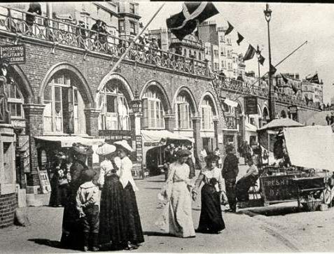 King's Road Arches, c. 1905: Edwardian ladies shopping at King's Road Arches with promenaders looking down over the railings. | Image reproduced with kind permission from Brighton and Hove in Pictures by Brighton and Hove City Council