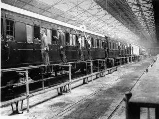 Painting Carriages at Brighton Railway Works, 1928: A team of men painting carriages by hand at the Brighton railway paint shop. The paint shop was built in 1878 to the north of Old Shoreham Road, and soon after this photograph was converted into an electric stock maintenance centre. | Image reproduced with kind permission from Brighton and Hove in Pictures by Brighton and Hove City Council