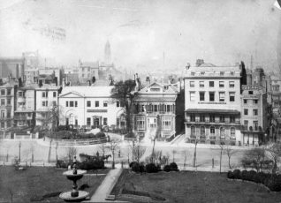 Buildings on West Side of the Old Steine, c. 1890: Marlborough House built in 1765 is the oldest remaining house on the Steine, and gained its name when owned by the fourth Duke of Marlborough between 1771 and 1786. In this photograph it was then the Brighton Board School Office. Steine House, built in 1804 for Maria Fitzherbert, is now a YMCA hostel. Blenheim House was then The Albany School for Girls. Victoria Fountain, supported by three entwined dolphins on a base of sarsen stones was installed at the centre of the Steine by Amon Henry Wilds in 1846 | Image reproduced with kind permission from Brighton and Hove in Pictures by Brighton and Hove City Council