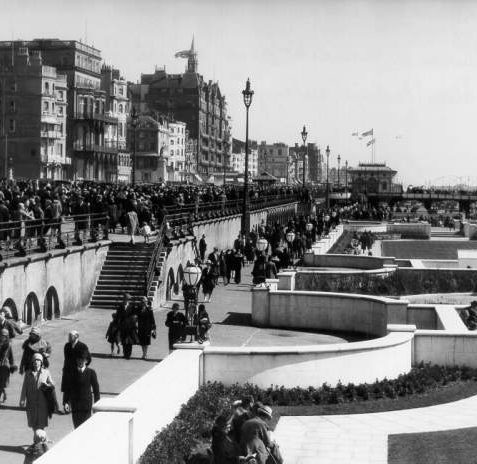 The Front and Sunken Gardens, c. 1925: The putting green, paddling pool and sunken gardens west of the West Pier were laid out in 1925 on the Lower Esplanade below King's Road. Here crowds of people are promenading along both the upper and lower esplanades. Photograph Crown Copyright Reserved. | Image reproduced with kind permission from Brighton and Hove in Pictures by Brighton and Hove City Council